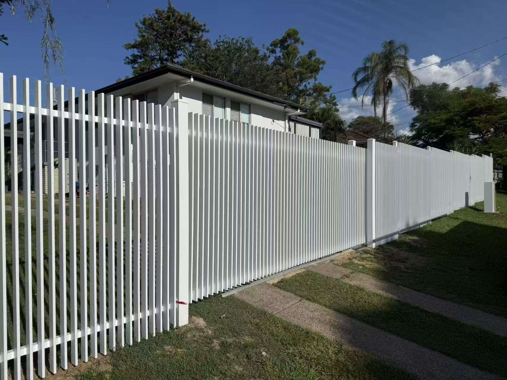 White aluminium vertical blade fence running the length of a street frontage in Brisbane