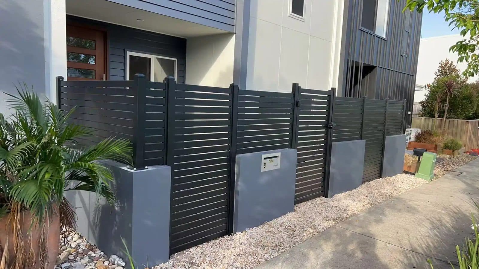 Monument grey horizontal slat aluminium fence and pedestrian gate at a modern home