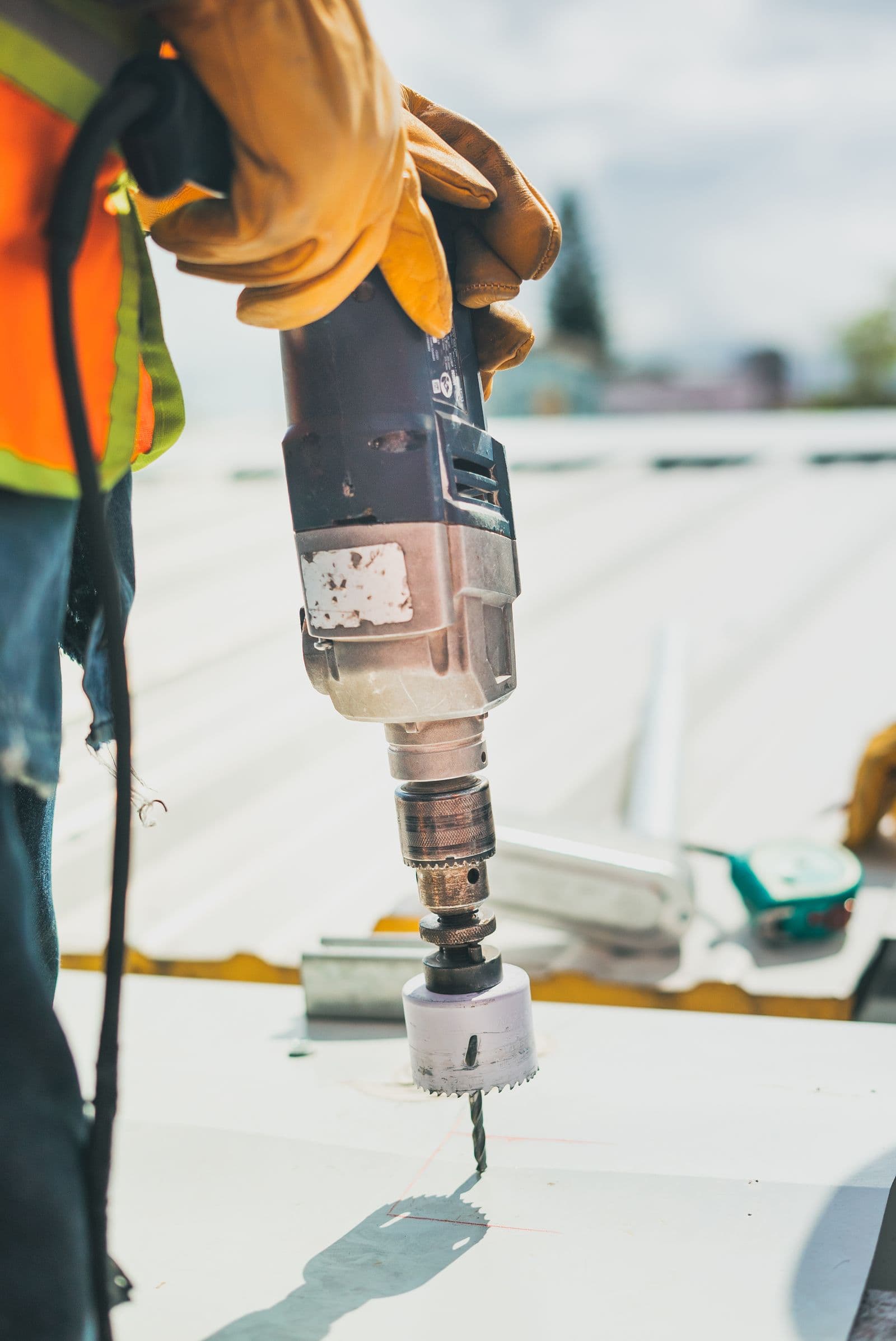 An installer drilling into metal with a power drill