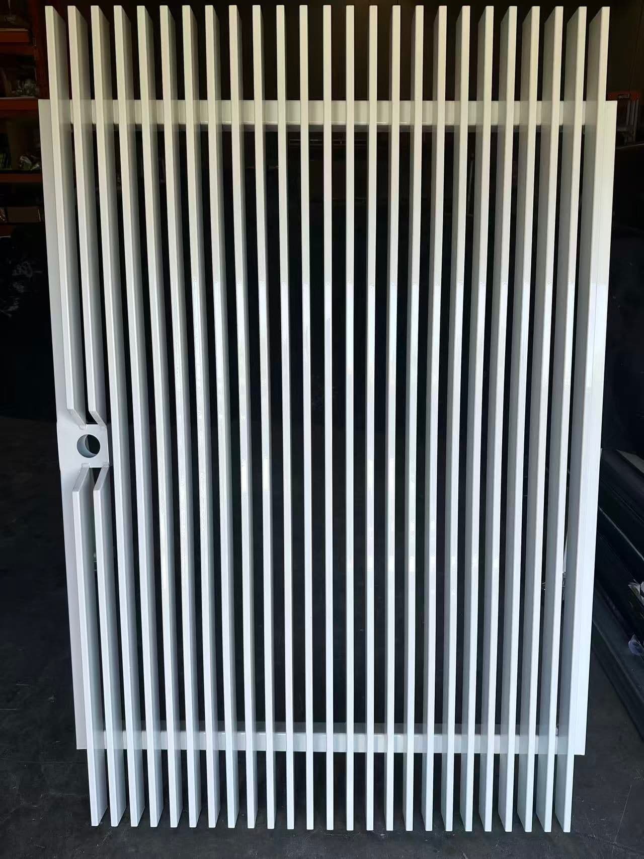A white welded vertical blade gate with its lock cut-out, finished and waiting at the FY Fencing yard